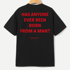 A black short-sleeve t-shirt hanging on a wooden hanger, showing the back with bold red text that reads 'HAS ANYONE EVER BEEN BORN FROM A MAN?'. A small red 'YLD' logo is printed below the text.