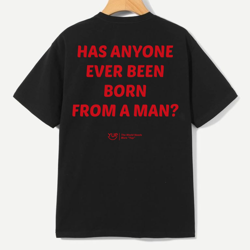 A black short-sleeve t-shirt hanging on a wooden hanger, showing the back with bold red text that reads 'HAS ANYONE EVER BEEN BORN FROM A MAN?'. A small red 'YLD' logo is printed below the text.
