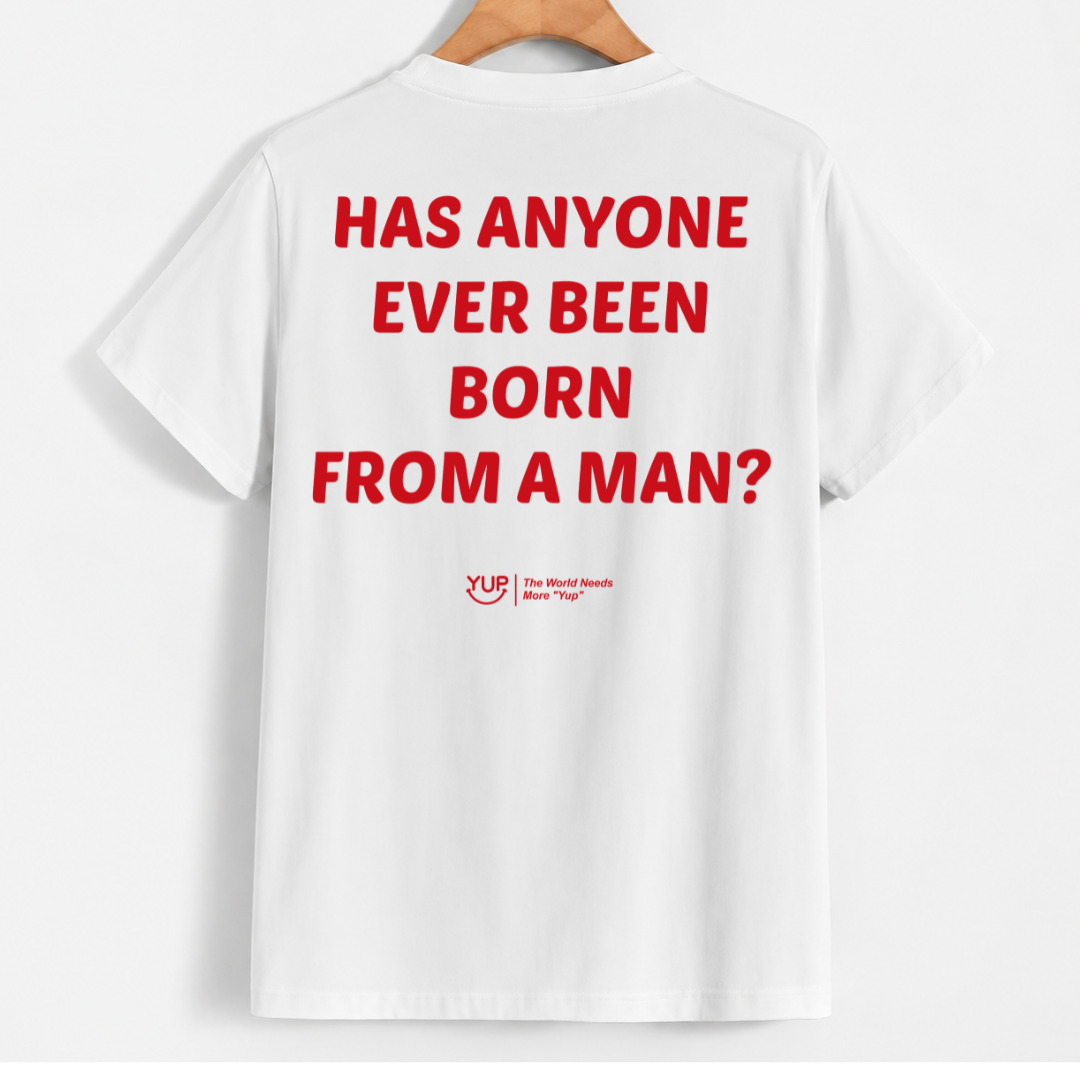 White short-sleeve T-shirt hanging on a wooden hanger against a light gray background, showing the back with large red text reading 'HAS ANYONE EVER BEEN BORN FROM A MAN?' and a small red YLD logo below.